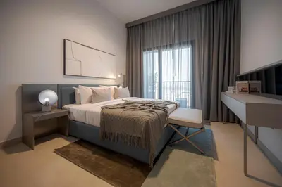 a bedroom with a bed and a desk and a window at Spacious Unit With Burj Khalifa View in Dubai