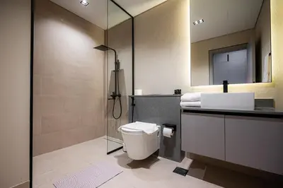 a bathroom with a shower and a toilet and a sink at Spacious Unit With Burj Khalifa View in Dubai