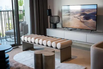 a living room with a tv and a bench at Spacious Unit With Burj Khalifa View in Dubai