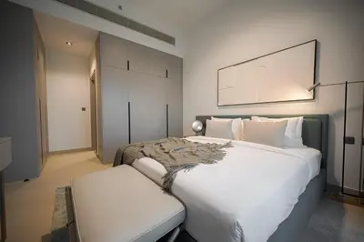 a bedroom with a large white bed and a chair at Spacious Unit With Burj Khalifa View in Dubai