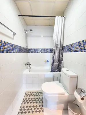 a bathroom with a toilet and a bath tub at Next to METRO 1BED with Panoramic Lake View in Dubai