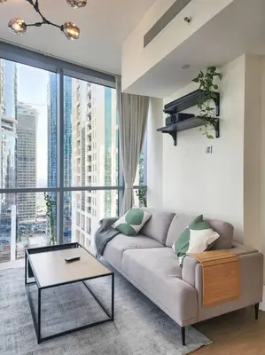 a living room with a couch and a large window at Next to METRO 1BED with Panoramic Lake View in Dubai