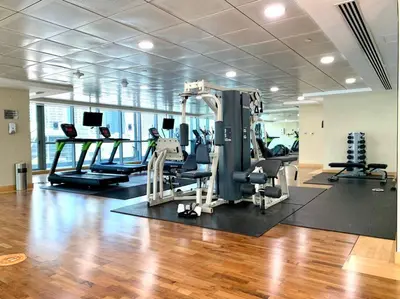 a gym with treadmills and machines in a room at Next to METRO 1BED with Panoramic Lake View in Dubai