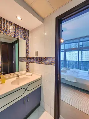 a bathroom with a sink and a mirror and a window at Next to METRO 1BED with Panoramic Lake View in Dubai
