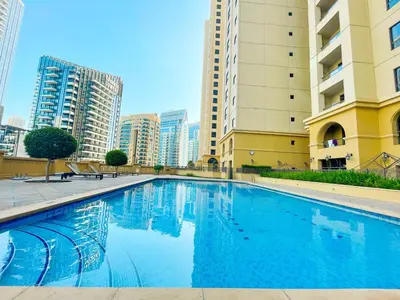 a swimming pool in a city with tall buildings at HAPPY SEASON JBR apartments in Dubai
