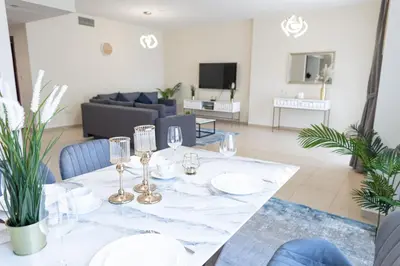 a dining room with a table and a couch at HAPPY SEASON JBR apartments in Dubai