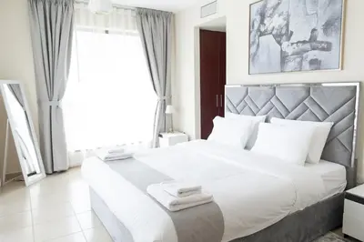 a bedroom with a large white bed with white pillows at HAPPY SEASON JBR apartments in Dubai
