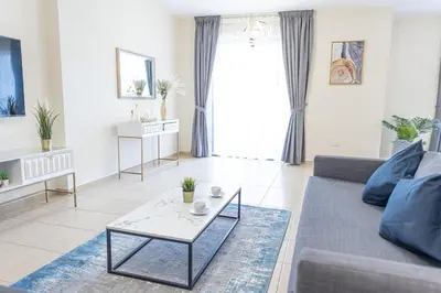 a living room with a couch and a table at HAPPY SEASON JBR apartments in Dubai