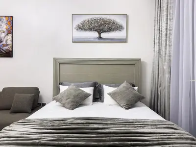 a bedroom with a bed with a tree on the wall at Furnished Studio Azizi Riviera 3 in Dubai