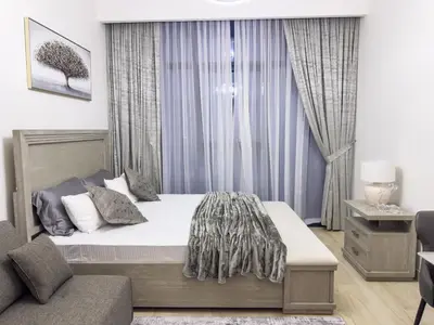 a bedroom with a large bed and a couch at Furnished Studio Azizi Riviera 3 in Dubai