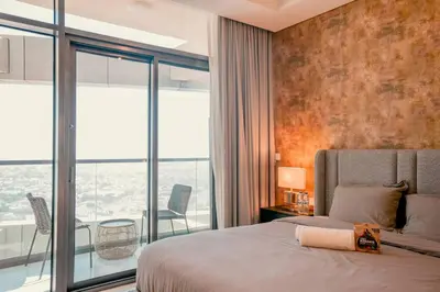 a bedroom with a bed and a large window at NEW Cozy & Stylish APT with Pool & Gym Access in Dubai