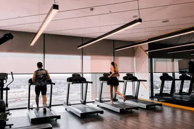 a man and woman on treadmills in a gym at NEW Cozy & Stylish APT with Pool & Gym Access in Dubai