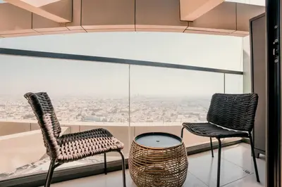 two chairs and a table in front of a window at NEW Cozy & Stylish APT with Pool & Gym Access in Dubai