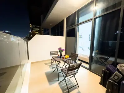 a dining room with a table and chairs on a balcony at Studio in Azizi Riviera Dubai in Dubai