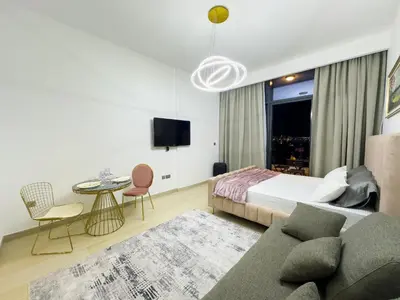 a bedroom with a bed and a couch and a table at Studio in Azizi Riviera Dubai in Dubai