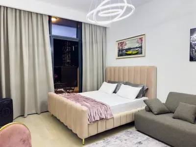 a bedroom with a large bed and a couch at Studio in Azizi Riviera Dubai in Dubai
