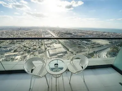 two chairs and a table on the top of a building at 50th Floor 2 Bed with Burj and Sea view in Dubai