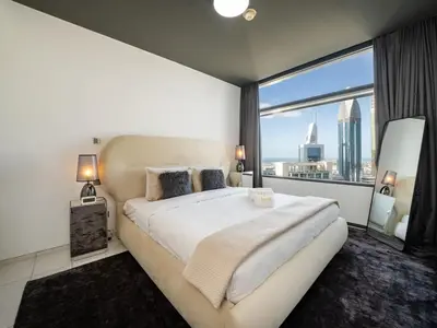 a bedroom with a large bed and a large window at Luxury 1-Bed DIFC Stay - City Views in a Prime Area in Dubai