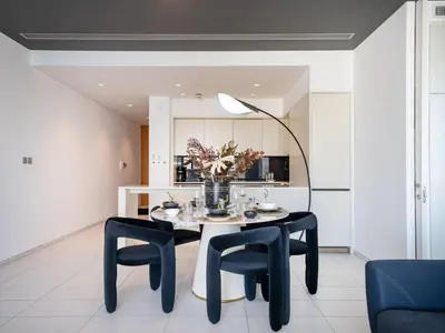 a dining room with a table with chairs and a lamp at Luxury 1-Bed DIFC Stay - City Views in a Prime Area in Dubai