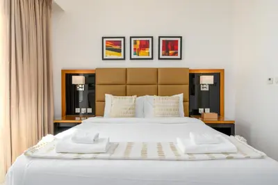 a large bed with white sheets and pillows at Vacay Lettings - DAMAC Capital Bay Tower in Dubai
