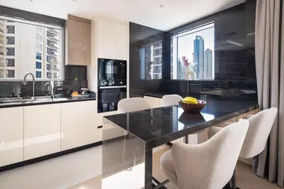 a kitchen with a black counter and white cabinets at Downtown Luxury Treat - Premium Location! 2 bedroom! in Dubai