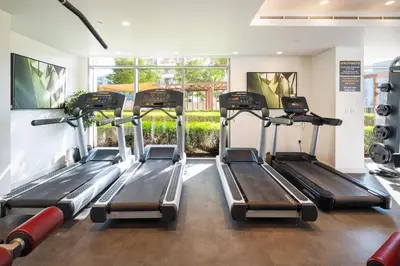 a gym with three treadmills in a room at Downtown Luxury Treat - Premium Location! 2 bedroom! in Dubai