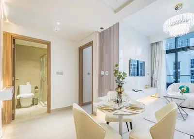 a living room with a table and chairs and a bathroom at Vacay Lettings Charming Retreat Azizi Riviera in Dubai