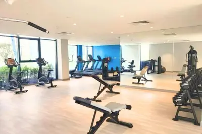 a gym with treadmills and exercise equipment in a building at Vacay Lettings Charming Retreat Azizi Riviera in Dubai