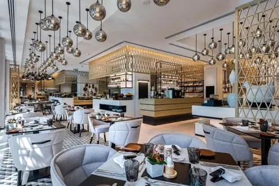 a restaurant with tables and chairs and a bar at Vacay Lettings Charming Retreat Azizi Riviera in Dubai