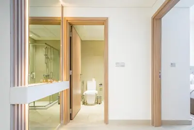 a bathroom with a toilet and a glass door at Vacay Lettings Charming Retreat Azizi Riviera in Dubai