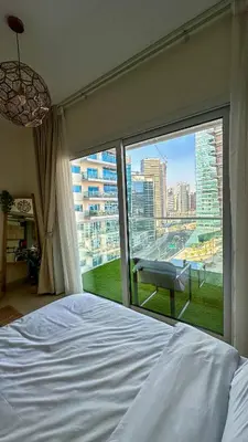 a bedroom with a bed and a large window at Stylish studio, center area, close to Burj Khalifa in Dubai