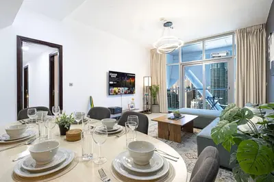 a living room with a table and a couch at 2BR on 30th Floor in JLT Near Metro & Walking Distance to JBR Beach, Dubai Marina in Dubai