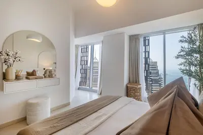 a bedroom with a large bed and a large window at Luxury 2BR in Cayan Tower with Sea, Marina & Dubai Eye View in Dubai