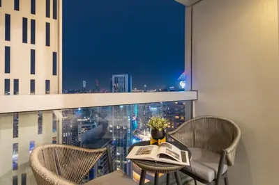 a table and chairs on a balcony with a view of a city at Luxury 2BR in Cayan Tower with Sea, Marina & Dubai Eye View in Dubai