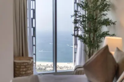 a view of the beach from a hotel room at Luxury 2BR in Cayan Tower with Sea, Marina & Dubai Eye View in Dubai