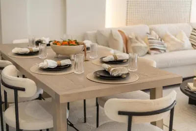 a wooden table with plates of food and a bowl of fruit at Luxury 2BR in Cayan Tower with Sea, Marina & Dubai Eye View in Dubai