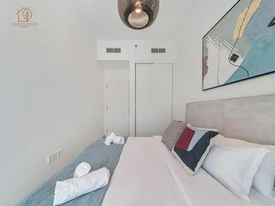 a bedroom with a bed and a clock on the wall at Stylish Apartment with Golf Views in Dubai Hills 199GV-2 in Dubai