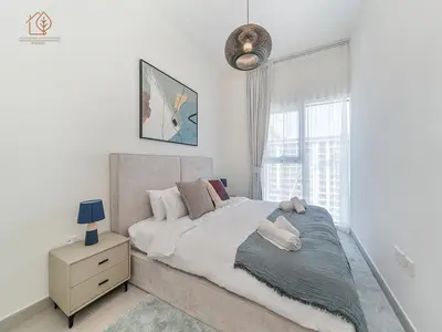 a bedroom with a large bed and a night stand at Stylish Apartment with Golf Views in Dubai Hills 199GV-2 in Dubai