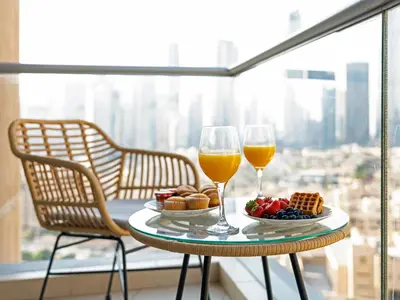 a table with two glasses of wine and a plate of food at Royal Vista - Luxury 2BR Apartment at Burj Views Tower A - Downtown in Dubai