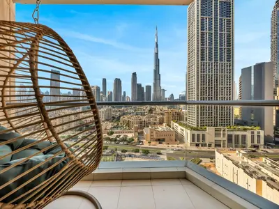 a hammock on a balcony with a view of the city at Royal Vista - Luxury 2BR Apartment at Burj Views Tower A - Downtown in Dubai