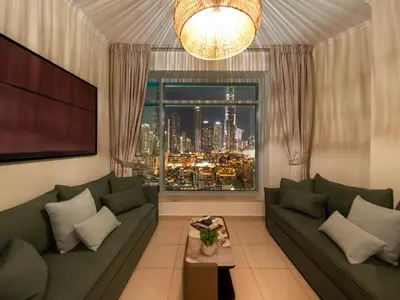 a living room with a couch and a large window at Royal Vista - Luxury 2BR Apartment at Burj Views Tower A - Downtown in Dubai