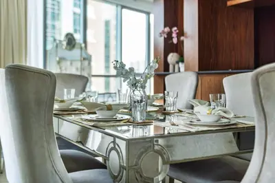 a dining room with a table with chairs and a vase of flowers at GuestReady - Charming stay with Burj Khalifa views in Dubai