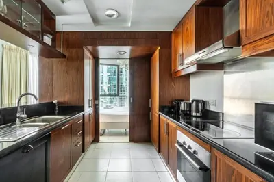 a kitchen with wooden cabinets and a sink at GuestReady - Charming stay with Burj Khalifa views in Dubai