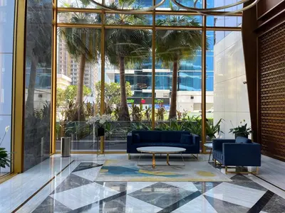 a lobby with blue couches and a table and palm trees at Dubai Marina stunning views holiday apartment Stella Maris Tower in Dubai