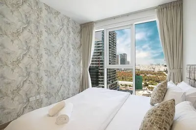 a bedroom with a bed and a large window at Chic 2 Bed Near Trade Centre with 5 Star Amenities in Dubai