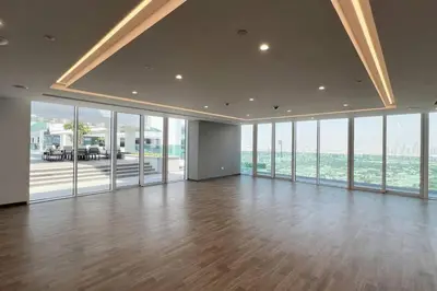 a large room with wood floors and glass windows at Chic 2 Bed Near Trade Centre with 5 Star Amenities in Dubai