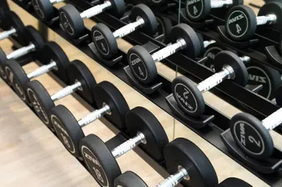a row of dumbbells in a gym at Modern 1br In Jvc Pool, Balcony & Free Parking in Dubai