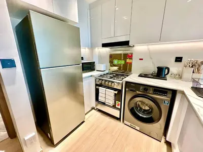 a kitchen with a stainless steel refrigerator and a dishwasher at Modern 1br In Jvc Pool, Balcony & Free Parking in Dubai