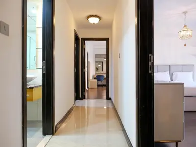 a hallway leading to a bedroom with a bed at Spacious 4BR Duplex with Terrace - JBR in Dubai