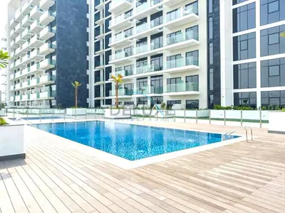 a swimming pool in front of a building at Chic Studio in Azizi Riviera 46, Al Merkadh by Deluxe Holiday Homes in Dubai